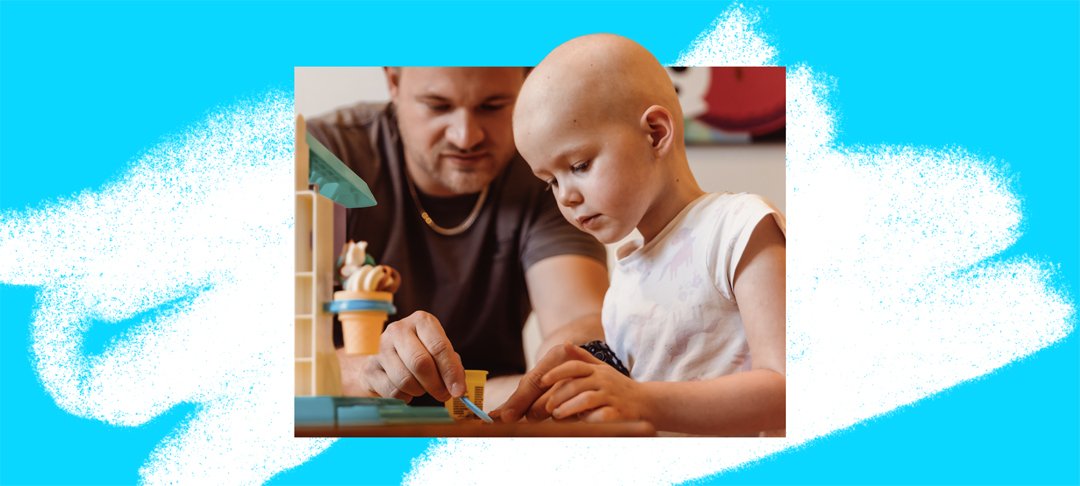 A little girl and her dad sitting next to each other playing with toys on a table