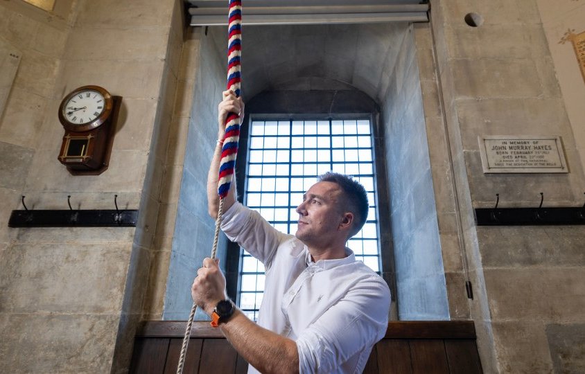 Man ringing bell inside cathedral