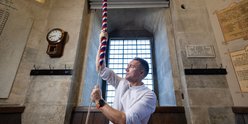 Man ringing bell inside cathedral