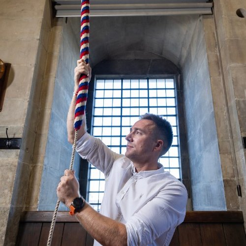 Man ringing bell inside cathedral