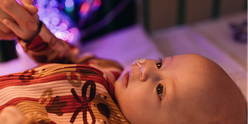 Baby in bed at GOSH. She is wearing a Christmas outfit and has an NG feeding tube.