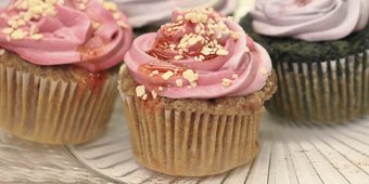 Four cupcakes with pink and purple icing