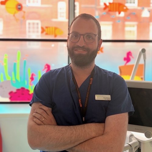 Man in scrubs standing by window