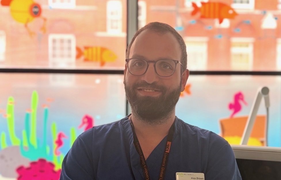 Man in scrubs standing by window