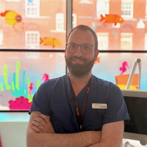 Man in scrubs standing by window
