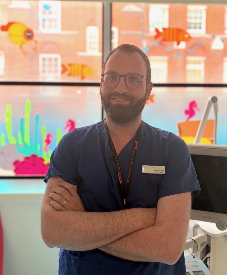 Man in scrubs standing by window