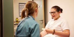 nurse sits with teenage girl in hospital room