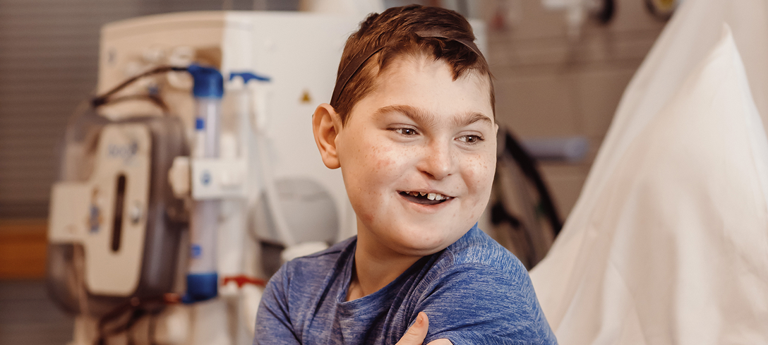 Boy sitting on hospital bed and smiling