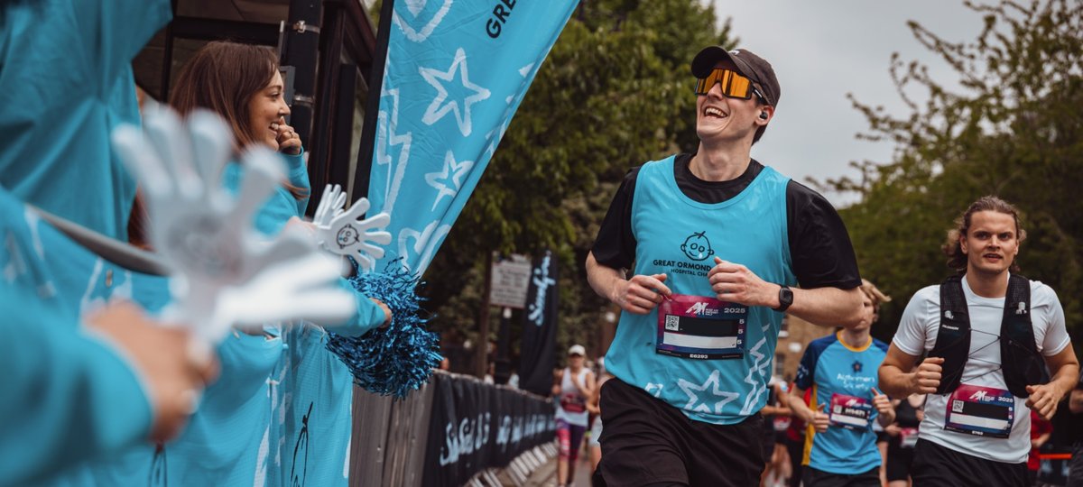 Hackney 2025 runner, smiling passing the GOSH Charity cheer point