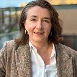 A woman with shoulder length brown hair is smiling at the camera