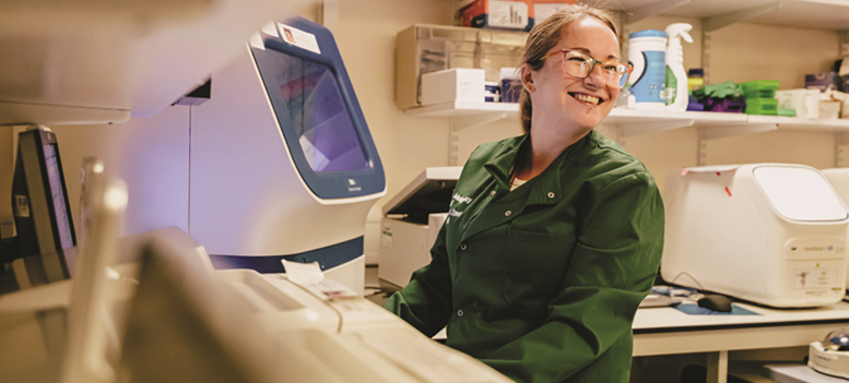 A woman laughing in a lab