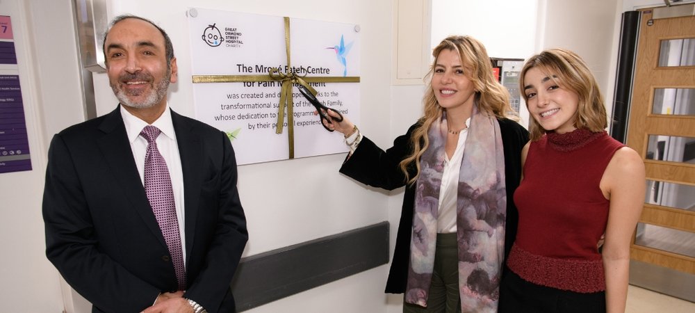 A man and two women stand next to a sign entitled The Mroué Fateh Centre for Pain Management