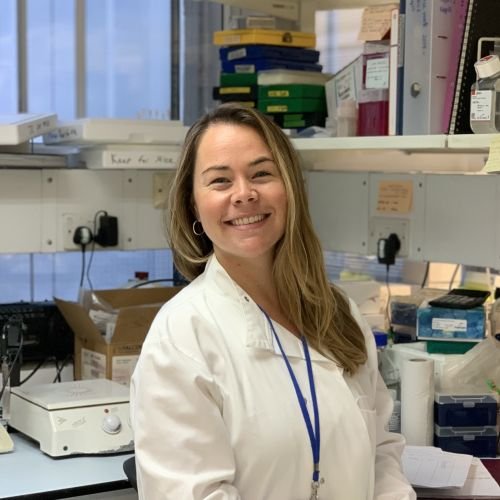 Dr Jennie Chandler in the lab, smiling at the camera