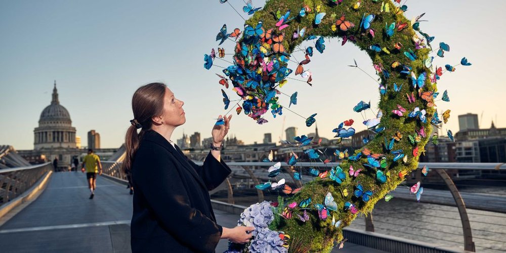 Woman looking at butterfly installation, St Paul's in the distance