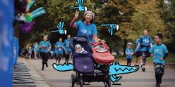 Race for the Kids participant smiles and waves to camera while pushing two babies in pushchair.