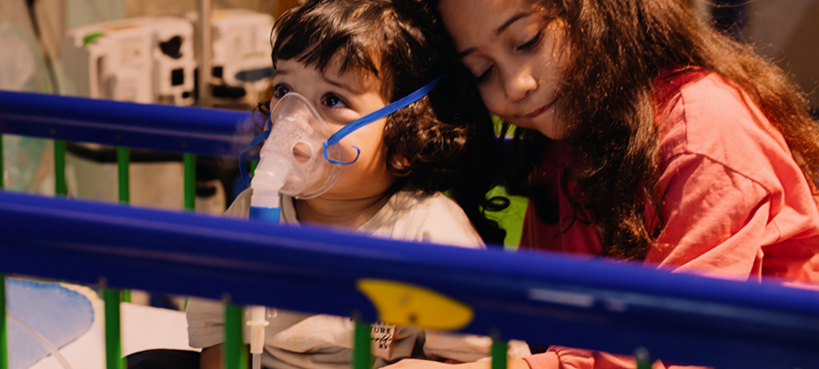 Two children sitting in a hospital bed