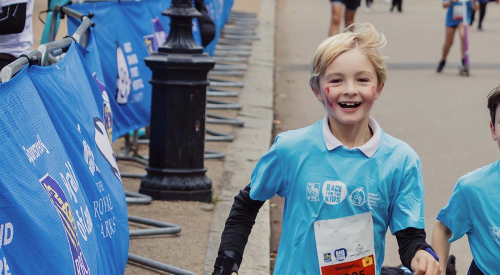Little boy running RBC Race for the Kids, smiling