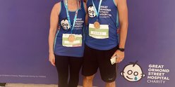A female and male runner smile at the camera