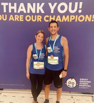 A female and male runner smile at the camera