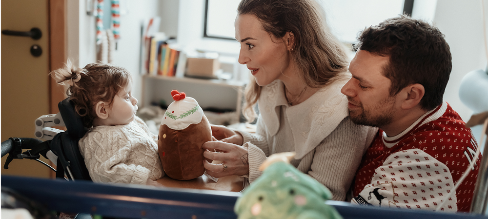 A little girl sits with her mum and dad