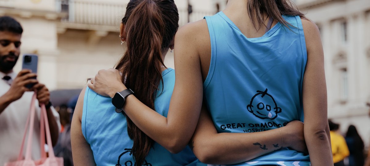 Two runners with their arms around each other, wearing GOSH Charity vests.