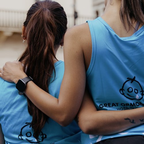 Two runners with their arms around each other, wearing GOSH Charity vests.