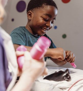 Little boy playing with arts and crafts in hospital, smiling