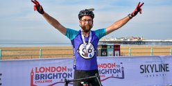 TeamGOSH cyclists on Brighton seafront with hands in the air