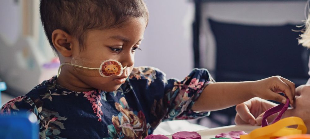 Photo of Yumna playing with play-dough while in room at GOSH