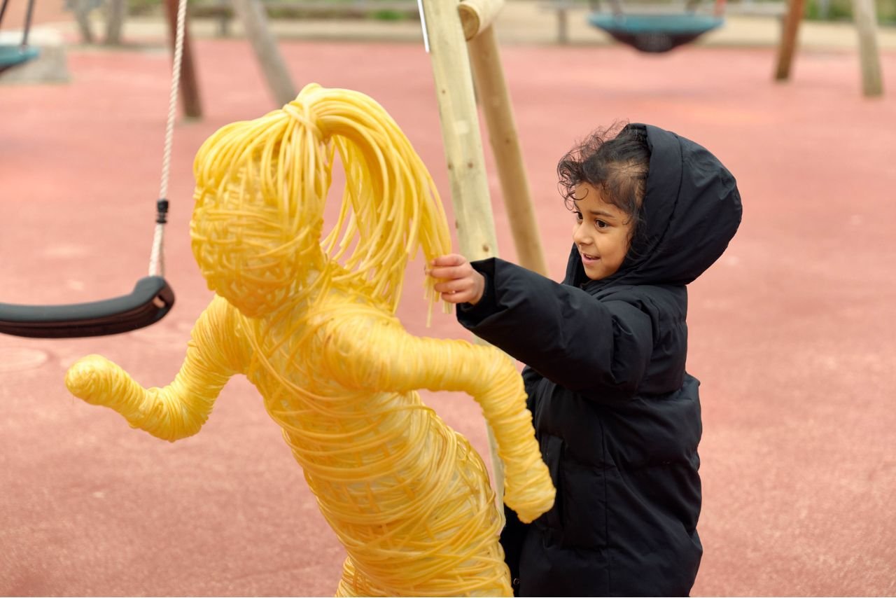 Little girl next to sculpture created using replica chemotherapy wires