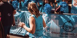 Woman running the London Landmarks Half Marathon for GOSH Charity runs past GOSH Charity cheer point