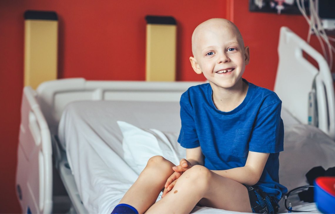 Little boy sitting on hospital bed, smiling to camera