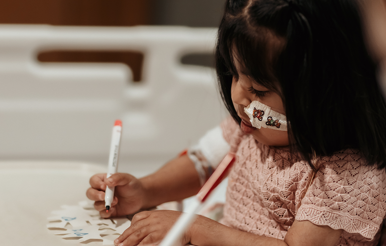 Little girl doing arts and crafts in her room in hospital