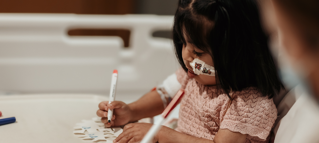 Little girl doing arts and crafts in her room in hospital