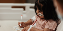 Little girl doing arts and crafts in her room in hospital