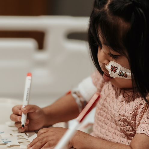 Little girl doing arts and crafts in her room in hospital
