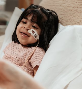 A little girl lying in a hospital bed